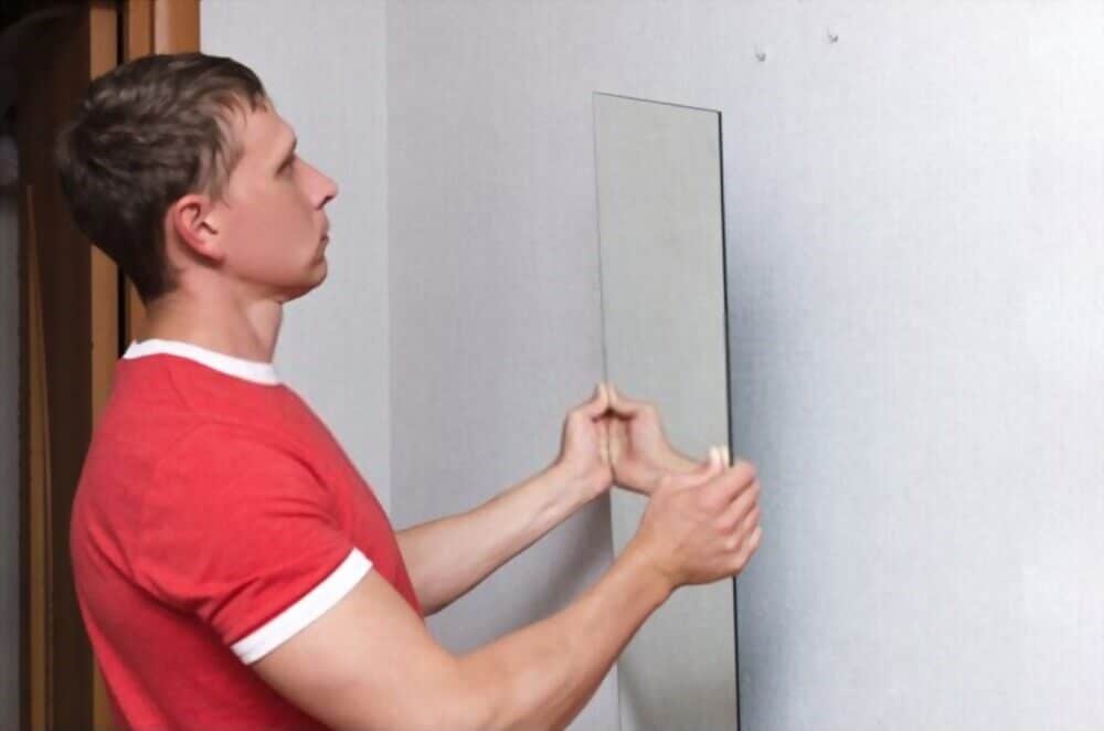 A Man is Removing is Frameless Mirror