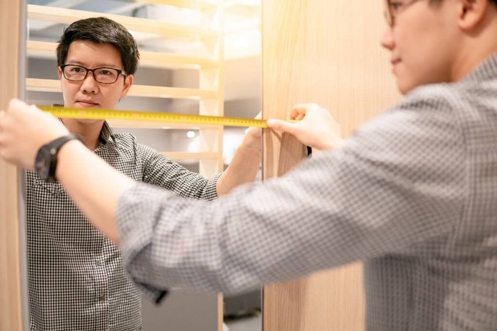 A Man is Measuring the Frameless Mirror