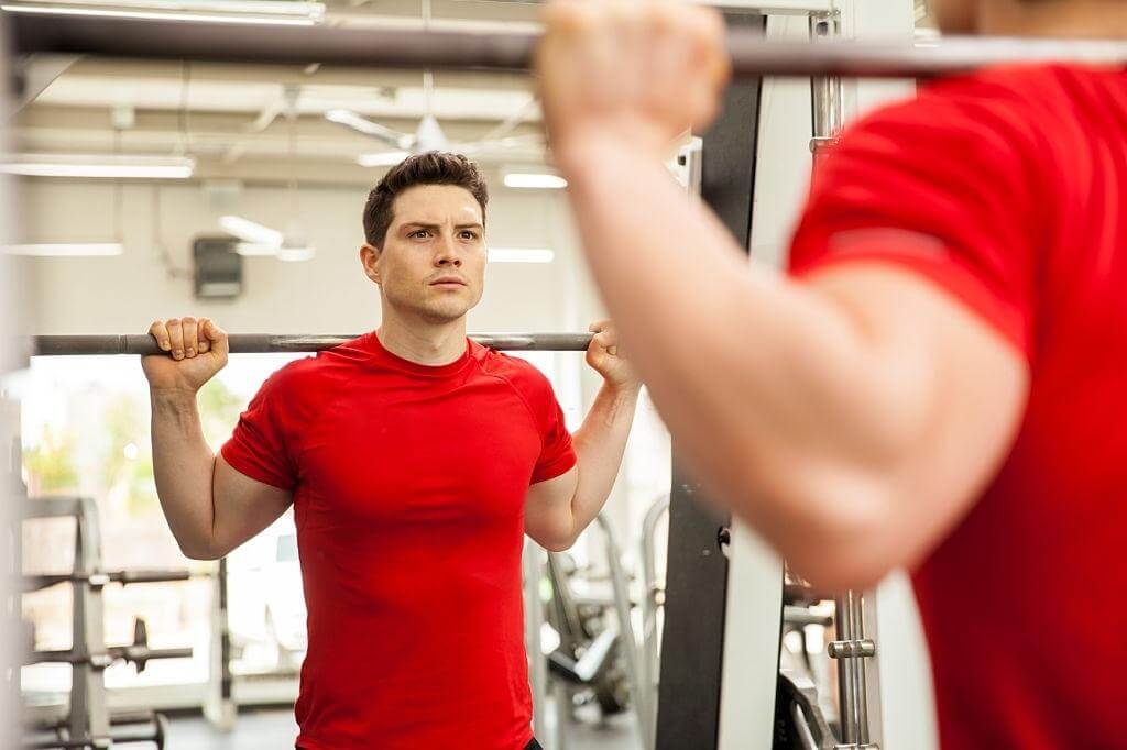 Man Doing Gym infront of Gym Wall Mirror